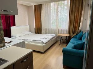 een kleine kamer met een bed en een blauwe bank bij Taksim Harbiye Apart Hotel in Istanbul