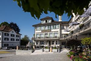 un grande edificio bianco con ombrelloni di fronte di Hotel Krone Gais a Gais