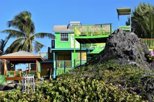 una casa colorida con una roca delante de ella en Coconut Walk Beach Apartment en Christ Church