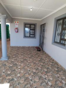 a room with a stone floor with a wall and windows at 4 Centenary Road Ixopo in Ixopo