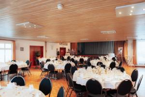 een feestzaal met witte tafels en stoelen bij Hotel Krone Gais in Gais