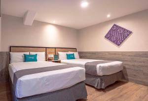 Habitación de hotel con 2 camas y almohadas azules en Ayenda Continental Mexicano, en Ciudad de México
