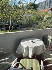 Apartmani Zelenika في هرسك نوفي: طاولة وكراسي على شرفة مع طاولة وكراسي