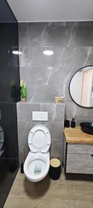 uma casa de banho com um WC branco e um espelho. em כוכב הצפון em Quriate-Chemoná