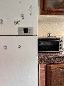 uma cozinha com um frigorífico branco e um micro-ondas em Dar Bennis em Rabat