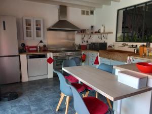 cocina con mesa de madera y sillas azules en Chambre(s) d'hôte chez Mam's en Beaucaire