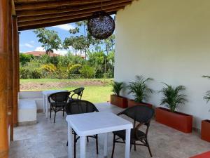 a patio with a white table and chairs and a window at Finca Monte del Sol in Quimbaya