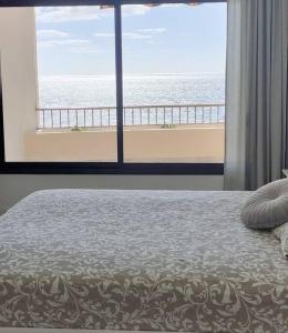 a bedroom with a bed with a view of the ocean at Apartamento vistas al océano in Radazul