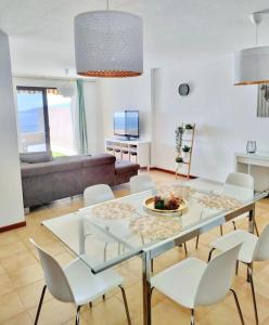 sala de estar con mesa de cristal y sillas blancas en Apartamento vistas al océano, en Radazul