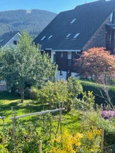 una casa con un patio con árboles y flores en Am Birkenhain en Titisee-Neustadt