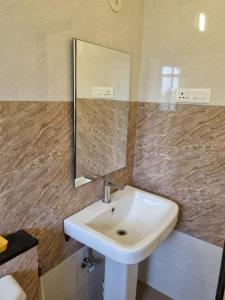 a bathroom with a sink and a mirror at Cinnamon House in Pune