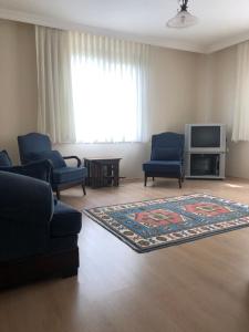 sala de estar con 2 sillas azules y alfombra en Emine Yılmaz’ın Evi, en Araklı