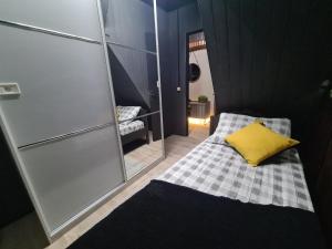a small bedroom with a bed with a yellow pillow at HOSTEL FAMILIA ZANATTA in Caxias do Sul