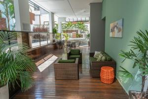 a lobby with chairs and tables and plants at Flat incrível e acessível ao lado da Paulista in São Paulo