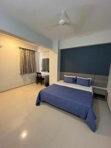 um quarto com uma cama grande e lençóis azuis em Cinnamon House em Pune