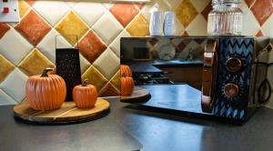 three pumpkins sitting on a counter next to a microwave at 6 Guests * 4 Bedroom * Free Wi-Fi in Burton Latimer