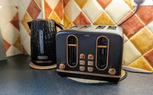 two toasters sitting on a counter next to a cup at 6 Guests * 4 Bedroom * Free Wi-Fi in Burton Latimer +15 photos