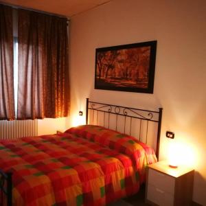 a bedroom with a bed with a colorful blanket and a window at The Best House in Reggio Emilia