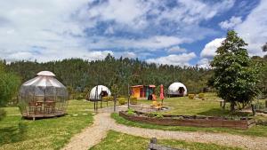 a group of tents in a field with trees at Aldebarán Farming & Glamping in Duitama