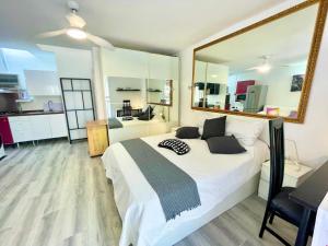 1 dormitorio con cama y espejo grande en Cozy Bungalow en Costa del Silencio