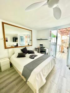 ein Schlafzimmer mit einem großen Bett und einem großen Spiegel in der Unterkunft Cozy Bungalow in Costa Del Silencio