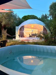 a large tent in a yard with a pool of water at Glamping Domes San Martino in Itri