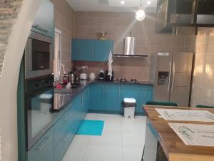 a kitchen with blue cabinets and a counter top at Le Lointain in Mtsamboro