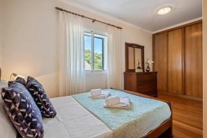 a bedroom with a bed with two towels on it at Casa do Palheiro Ribeirinho in Porto Moniz