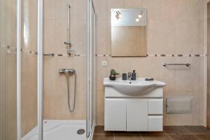 un baño con lavabo y ducha en Casa do Palheiro Ribeirinho, en Porto Moniz