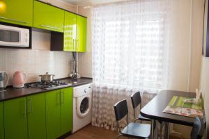 une cuisine avec des placards verts et une table avec des chaises dans l'établissement Шато, à Petropavlovsk-Kamtchatski