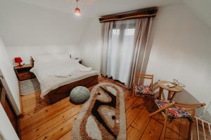 um quarto com uma cama e piso em madeira em Pleta View em Vatra Dornei