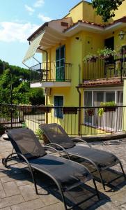 a group of lawn chairs in front of a building at B&B Massico Apartments in Sant'Agnello