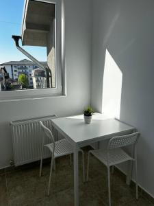 ColentinaにあるBrand New Apartment with Self check in - Spital Fundeni -Dragonul Rosuの窓付きの客室で、白いテーブルと椅子が備わります。