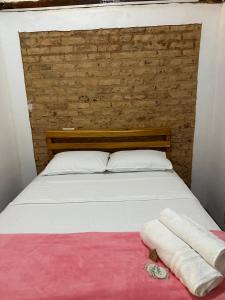 Estancia do Castello的住宿－Chácara da Tuia，一张带两条毛巾的床铺,放在粉红色的毯子上