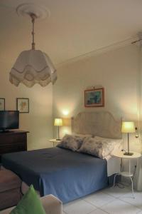 a bedroom with a bed and a chandelier at B&B Massico Apartments in Sant'Agnello