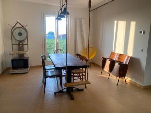 a dining room with a table and chairs and a clock at Relaxing house with exclusive swimming pool, close to Imola and Faenza, 4 bathrooms in San Mauro +13 photos