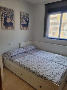 een groot bed in een kamer met een raam bij Apartamento en el Grau de Moncofa entre 2 y 3 linea de playa in Moncófar