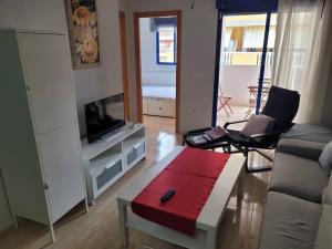 een woonkamer met een bank en een tv bij Apartamento en el Grau de Moncofa entre 2 y 3 linea de playa in Moncófar