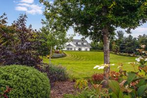 a white house with a tree in a yard at The Ridgewood Lodge in Newbridge