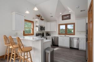 a kitchen with white cabinets and bar stools at The Duck Social in Kitty Hawk
