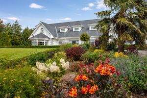 a house with a flowering garden in front of it at The Ridgewood Lodge in Newbridge
