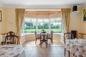 een eetkamer met een tafel en stoelen bij The Ridgewood Lodge in Newbridge