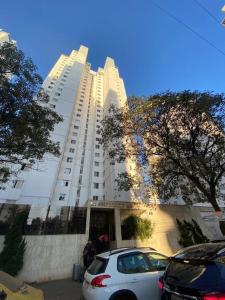 un coche blanco estacionado frente a un gran edificio en Apartamento aconchegante no Setor Bueno, en Goiânia 15 fotos más