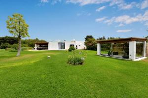 una casa con un cortile con un prato verde di Masseria San Rocco a Gallipoli