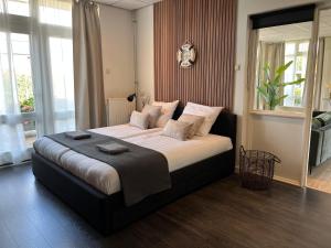 a bedroom with a large bed in a room at The marine apartment near Amsterdam by Weltevreden Experience in Kortenhoef