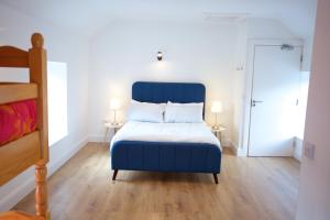 a bedroom with a blue bed and two lamps at Rock House Sligo in Riverstown