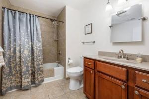 Un baño con inodoro, lavabo y ducha. en Modern Golfview Condo near the Grand Traverse Bay, en Williamsburg 27 fotos más