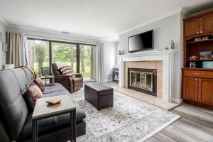 a living room with a couch and a fireplace at Modern Golfview Condo near the Grand Traverse Bay in Williamsburg