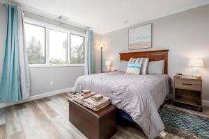 a bedroom with a large bed and a window at Modern Golfview Condo near the Grand Traverse Bay in Williamsburg