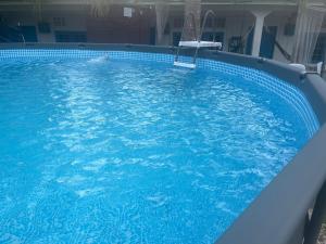 a large blue swimming pool with a chair in it at Dar Yasmine in Pantai Cenang